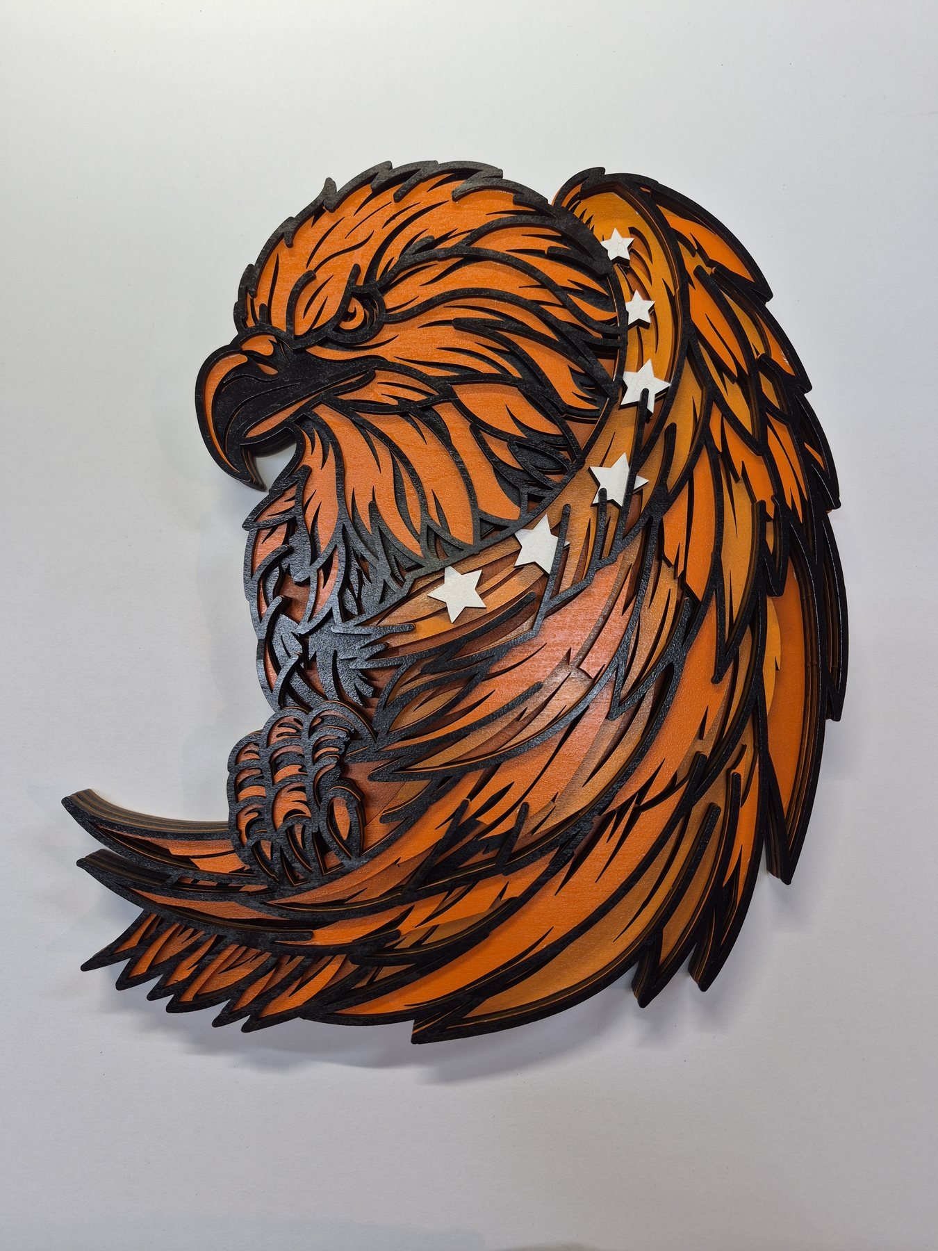 Dimensional eagle artwork with layered feathers on a wooden presentation plaque.