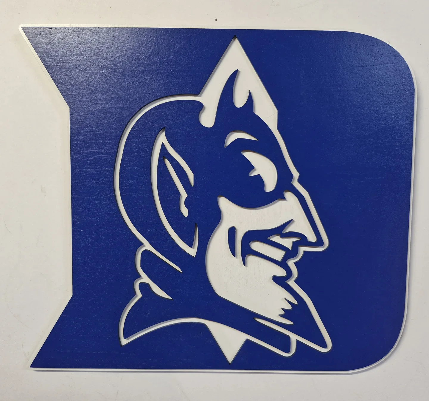Blue and white dimensional Blue Devils emblem cut to the outline of the logo.