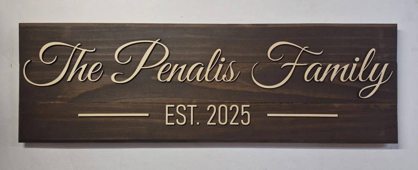 Personalized family established sign with script lettering and a date on dark wood.
