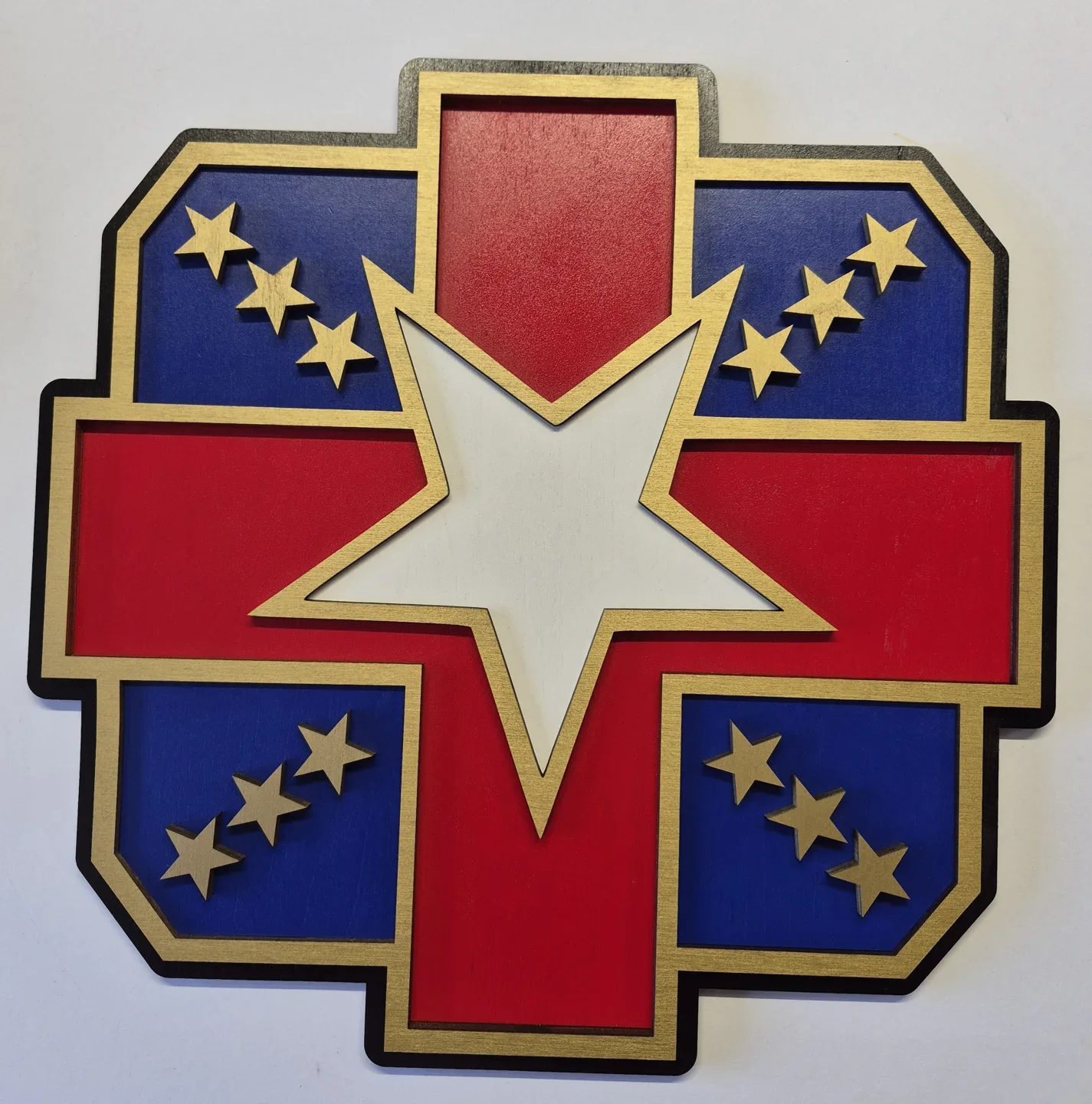 Red and blue military cross emblem with gold stars and a large central star.
