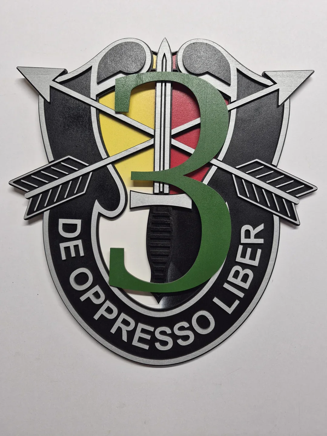 Special Forces presentation emblem with crossed arrows and green and red raised details.