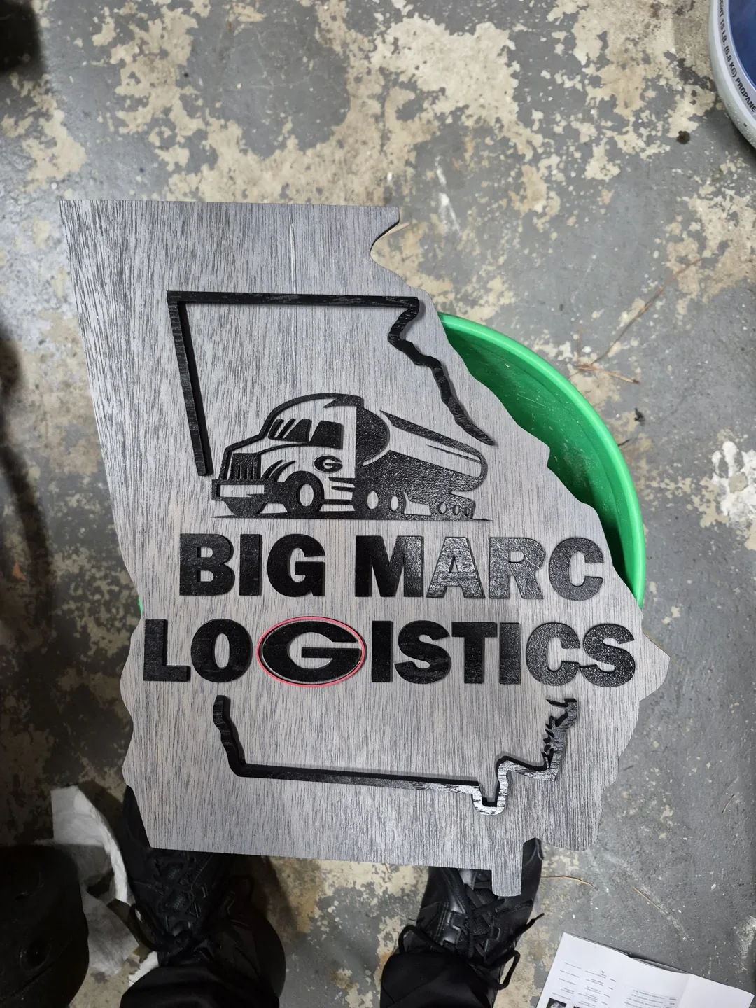 Big Marc Logistics business sign with a truck graphic and contrasting green and black lettering.