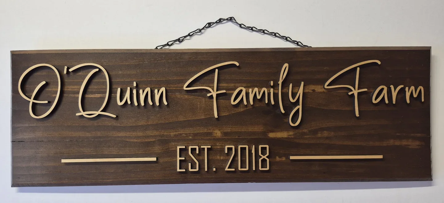 Personalized family farm established sign with script lettering on dark wood.