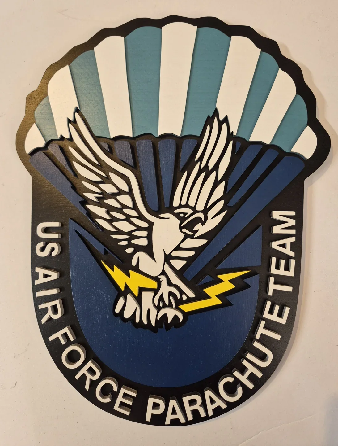 Saber Force parachute team plaque with an eagle beneath a striped parachute canopy.