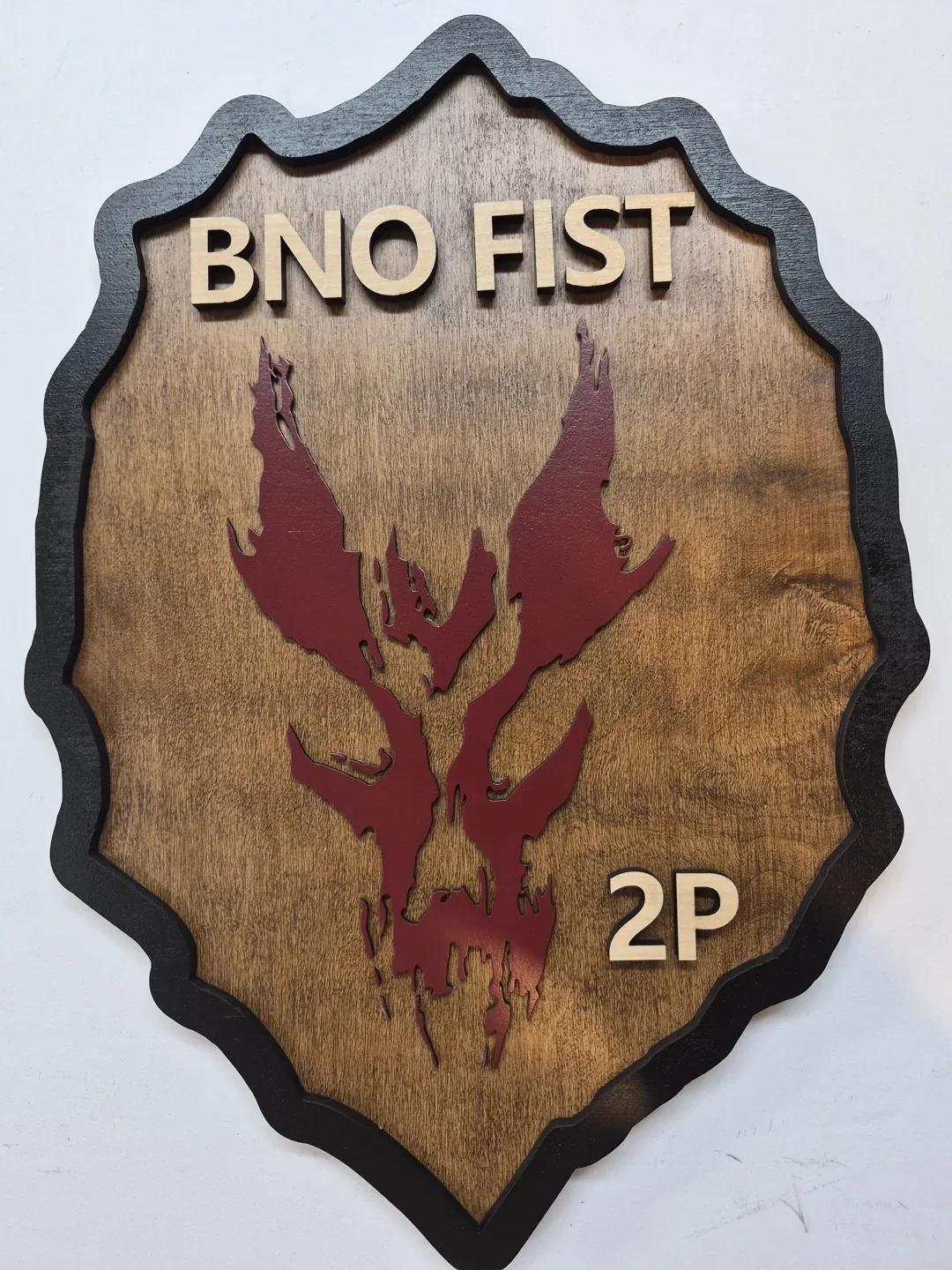 BNO FST wooden shield with a dark red stag and a natural wood background.