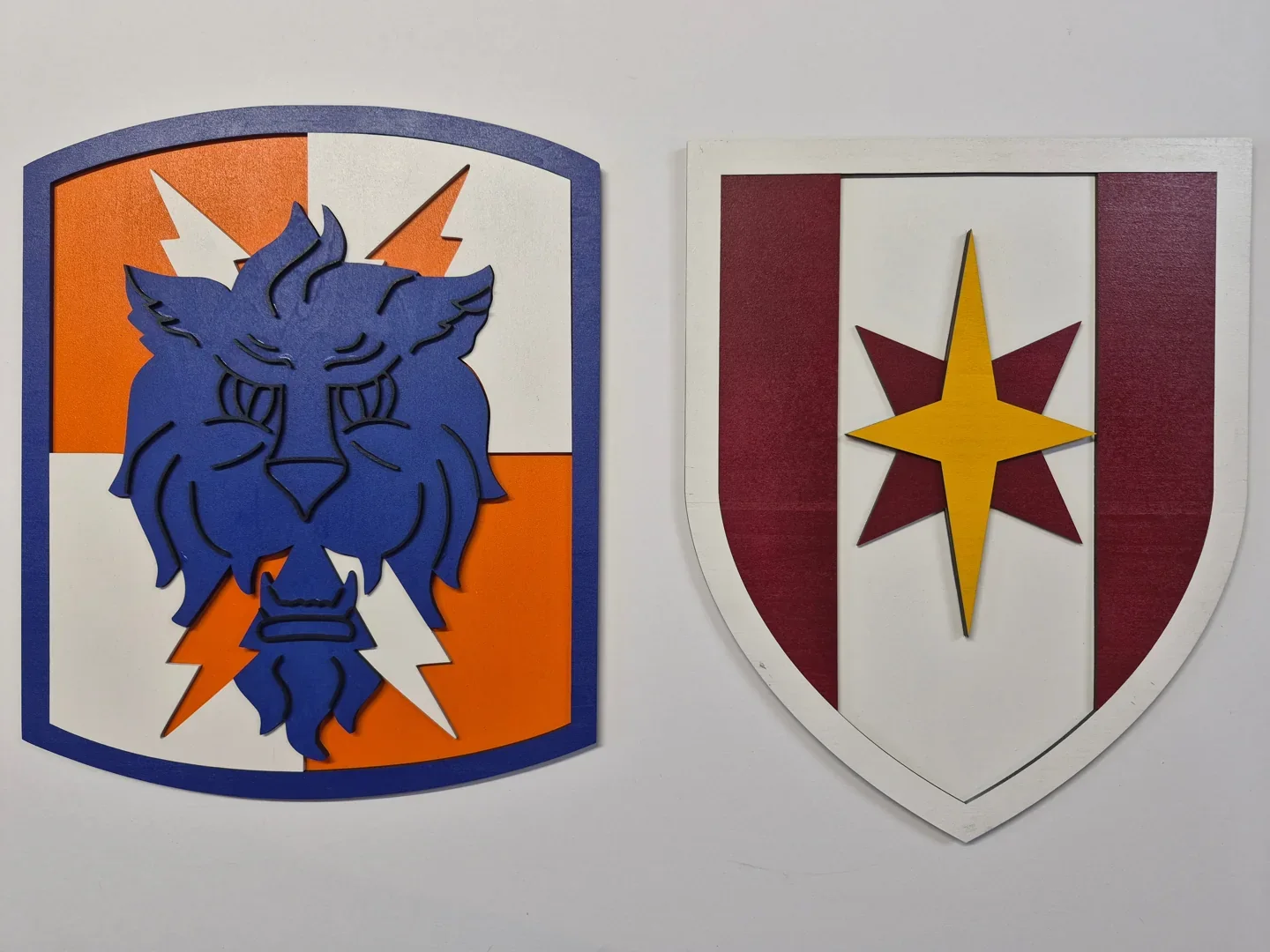 Pair of custom unit crest plaques with a blue wildcat and a red and white star shield.