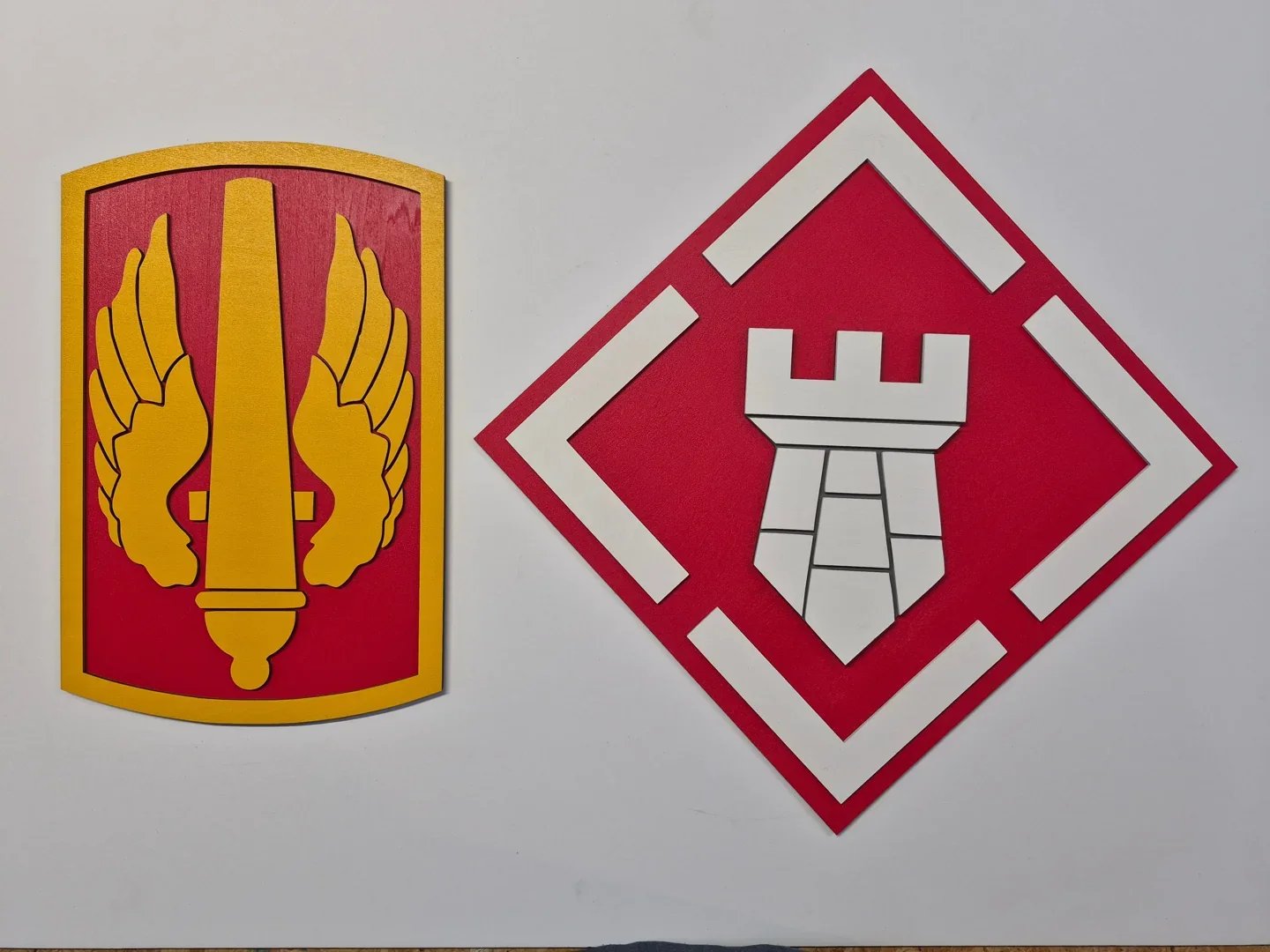 Pair of military branch plaques with a flaming sword and a white castle.